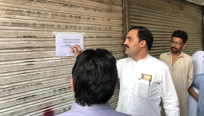 District administration official sealing book shop in Mingora on April 8, 2025. — Facebook@dcoswat