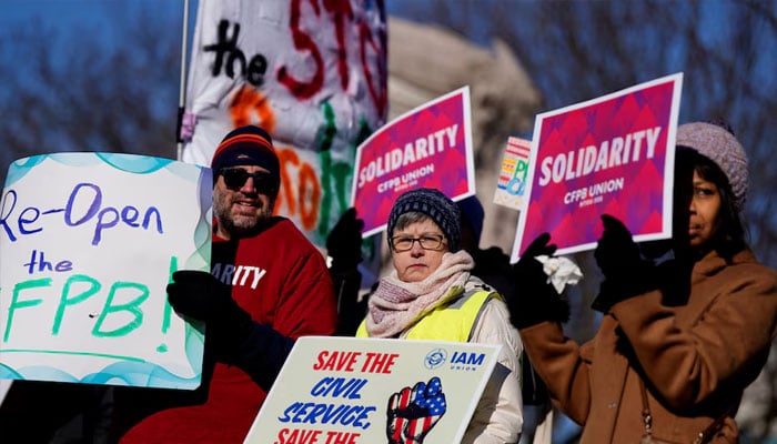 Consumer Financial Protection Bureau (CFPB) workers hold placards as they rally on the day of a hearing in a case on the Trump administrations mass firings of CFPB workers, outside the US District Court in Washington, DC, US, March 3, 2025.—Reuters