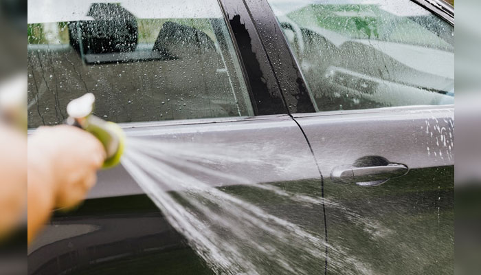 A representational image shows a man wash his car. — Pexels/File