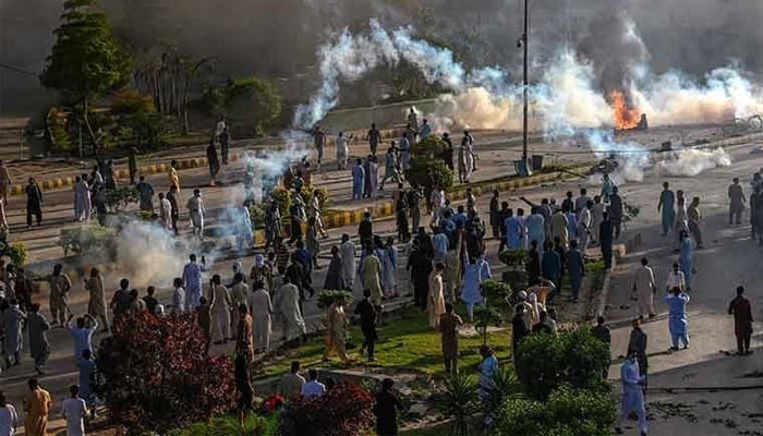 Police fire teargas shell towards Pakistan Tehreek-e-Insaf party activists and supporters of former Pakistan Prime Minister Imran to dispers them during a protest against the arrest of their leader on May 9, 2023. — AFP