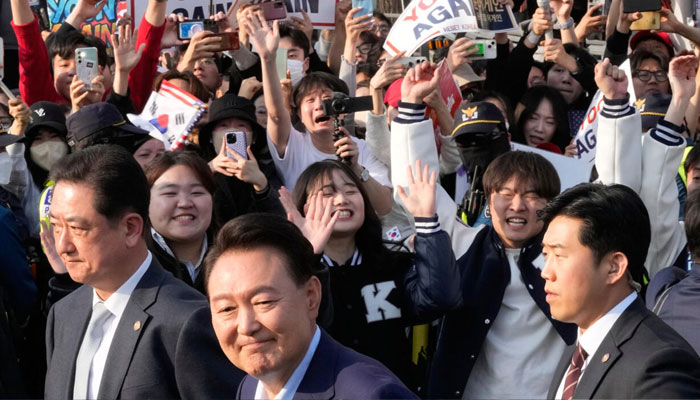 Yoon Suk Yeol (front center) leaving the presidential residence in Seoul to the cheers of supporters. — AFP/File