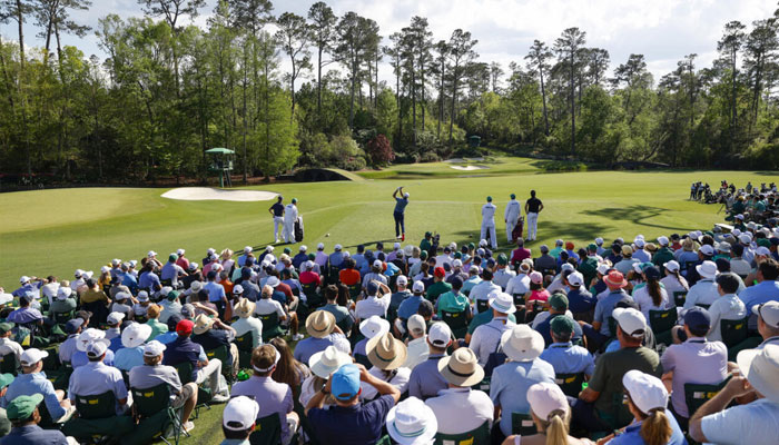 Defending champion Scottie Scheffler (centre) plays the 12th hole of Augusta National in the second round of the Masters. —AFP/File