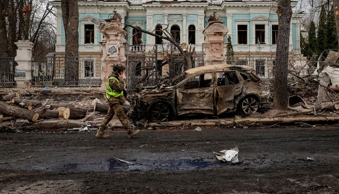 A soldier passing by a destroyed car in Sumy, Ukraine April 13, 2025.—Reuters