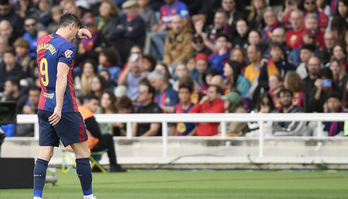 Barcelonas Polish forward Robert Lewandowski leaves the pitch injured against Celta Vigo. —AFP