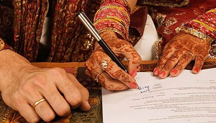 A representational image showing a bride signing Nikah papers. — Facebook@Nikah Halal/File