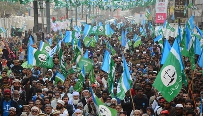 Supporters of the Jamaat-e-Islami protest holding flags at a rally. — Online/File