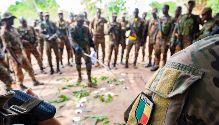 A Beninese platoon lieutenant uses a sand table diagram to discuss squad assignments. —US Air Force/File