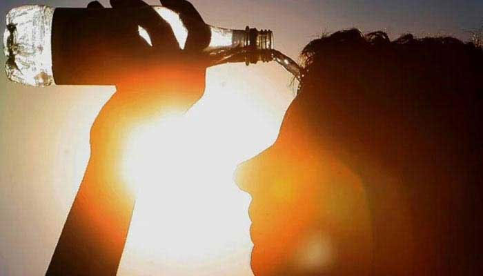 A representational image showing silhouette of a woman pouring water from a bottle on her head in front of the sun. — AFP