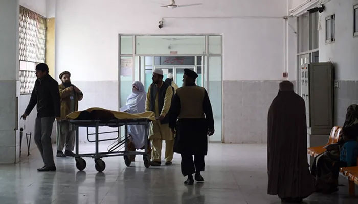 Pakistani relatives tend to a man treated at a hospital in Peshawar. — AFP/File