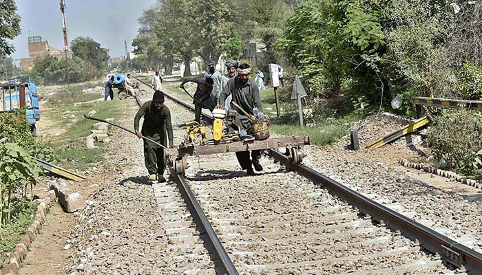 Pakistan Railway workers busy repairing railway tracks during maintenance work near Railway Station. — APP/File