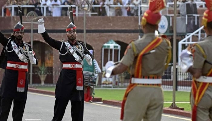 In this photograph taken on August 1, 2022, Indian Border Security Force (BSF) soldiers (in brown) and Pakistani Rangers take part in the Beating the Retreat ceremony at the India-Pakistan Wagah border post. — AFP