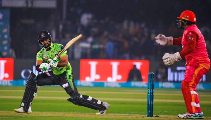 A Lahore Qalandars batter hits a shot as an Islamabad United wicketkeeper looks on during the 16th match of the eighth season of the Pakistan Super League (PSL) at the Gaddafi Stadium in Lahore on February 27, 2023. — PSL