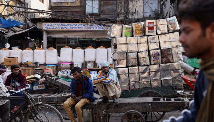 Workers sit on a cart at a wholesale market in the old quarters of Delhi, India. — Reuters/File