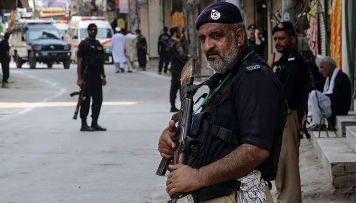 Policeman stands guard ahead of a Muharram procession in Peshawar on August 7, 2022. — AFP