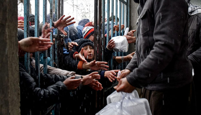 Afghan children receive food aid from a local charity in Mazar-i-Sharif on March 2, 2025. — AFP