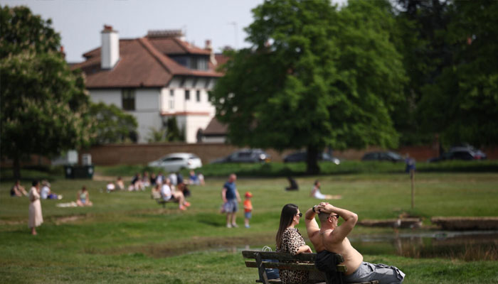 People bask in the record heat at Londons Wimbledon Common. —AFP/File