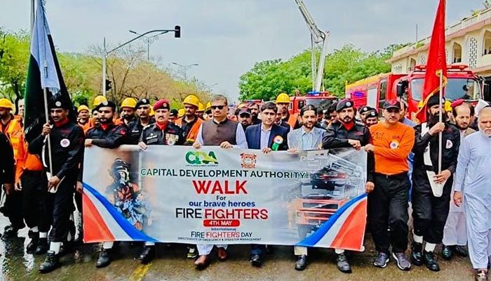 CDA Member Administration Talat Mahmood as the chief guest hold banner with others in a public awareness walk to mark International Firefighters’ Day on May 4, 2025. — Facebook@cda.isb.pk