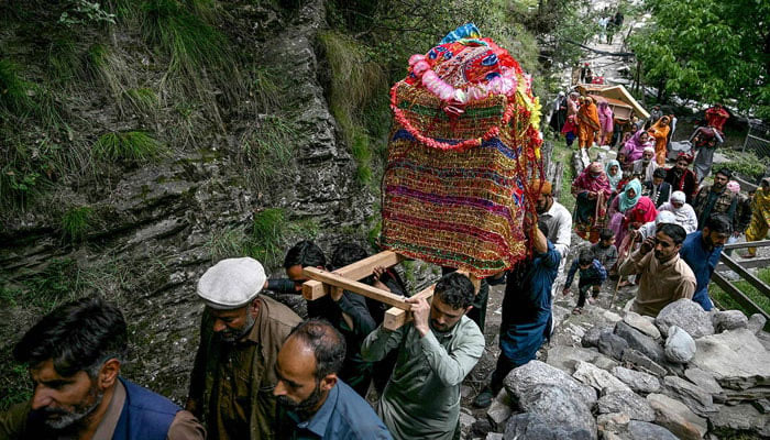 Relatives carry the bride, Rabia Bibi, in a Doli, a traditional hand cart used to carry brides at weddings, as they leave for the grooms house in Ashkot village on the Line of Control (LoC) in Neelum Valley, district of Azad Kashmir, on May 3, 2025. — AFP