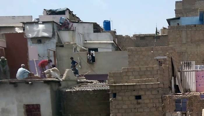 Citizens working over roof near Gujjar Nallah Karachi. —TheNews/File