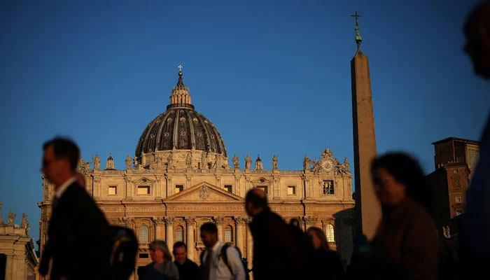 People walk in front of St. Peters Basilica in St. Peters Square ahead of the conclave, which will be held on May 7, at the Vatican, April 30, 2025.—Reuters