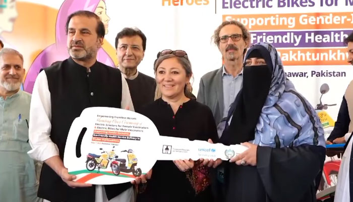 Advisor to Chief Minister on Health Ihtisham Ali (left) handing over the keys to the female recipient during a ceremony on May 7, 2025. — Screengrab via Facebook@HealthKPGovt