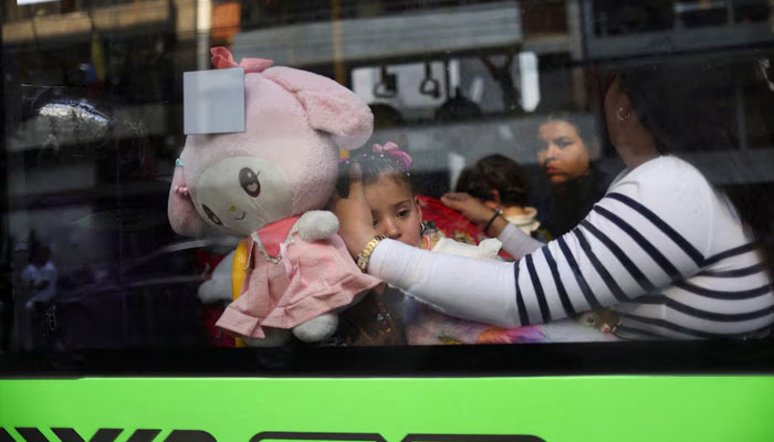 A migrant girl from Venezuela looks on through the window of the bus taking her and her family to their embassy, while on their way to take a flight back to Venezuela, in Mexico City, Mexico May 7, 2025.—Reuters