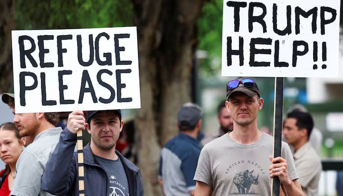 Demonstrators hold placards in support of US President Donald Trumps stance against what he calls racist laws, land expropriation, and farm attacks, outside the American Embassy in Pretoria, South Africa, February 15, 2025. — Reuters