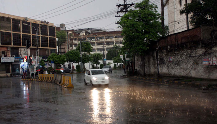Commuters are passing through a road during the downpour of summer season, at Shimla Hill in Lahore on May 11, 2025. — PPI