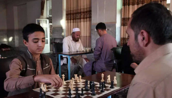 In this picture taken on June 30, 2022, people play chess games during a chess tournament in Kandahar, Afghanistan — AFP