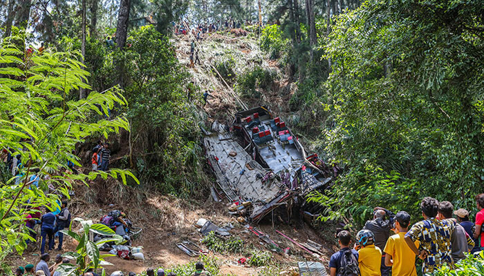 People gather at the site of a bus accident in the central hilly region of Kotmale on May 11, 2025. — AFP