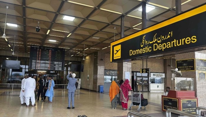 Passengers wait at Jinnah International Airport after all domestic and international flights were cancelled in Karachi on May 7, 2025. — AFP