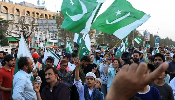 People wave flags in celebration after the ceasefire announcement between Pakistan and India on May 10, 2025. — Reuters