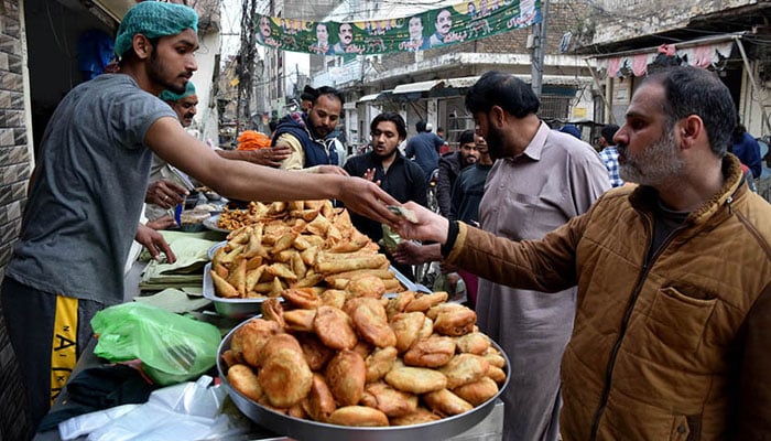 People purchasing traditional food items in Rawalpindi. — APP/File