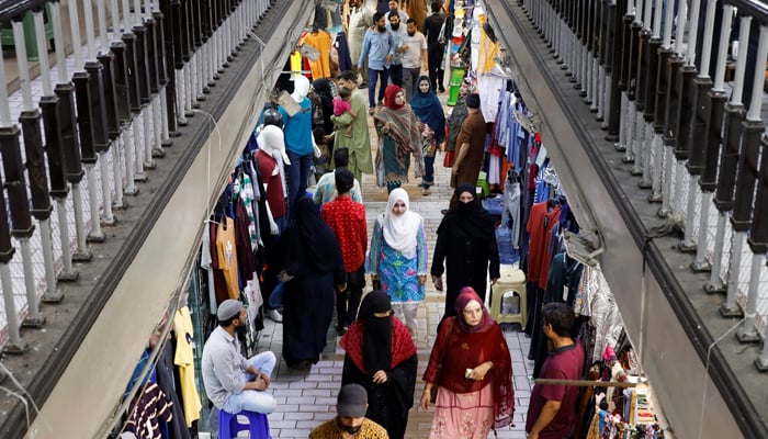 People walk as they shop in a market, ahead of Eid ul Fitr celebrations in Karachi, on April 19, 2023. — Reuters