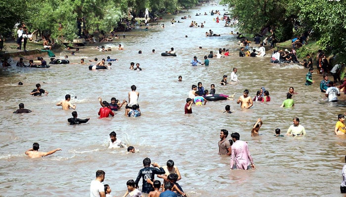 People enjoying bathing at BRB canal during hot weather in Lahore on May 19, 2025. — INP