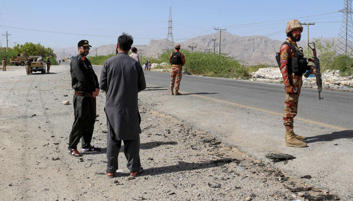 Security personnel stand guard at the site of a school bus bombing in Khuzdar district of Balochistan province on May 21, 2025. — AFP