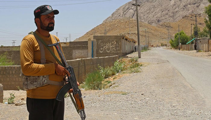 A security personnel stands guard along a street near the site of a school bus bombing in the Khuzdar district of Balochistan province on May 21, 2025. — AFP