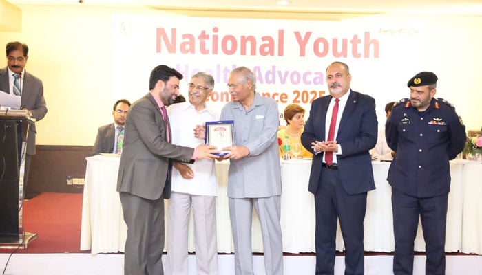 Participant receives a shield from the President PANAH Major General (r) Masud Ur Rehman Kiani (centre) at the National Youth Advocacy Conference on May 22, 2025. — Facebook@GYAssociation