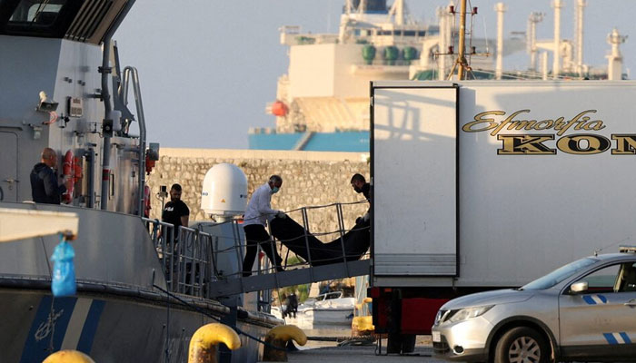 Men transfer body bags carrying migrants who died after their boat capsized in the open sea off Greece, onboard a Hellenic Coast Guard vessel at the port of Kalamata, Greece, June 15, 2023.—Reuters