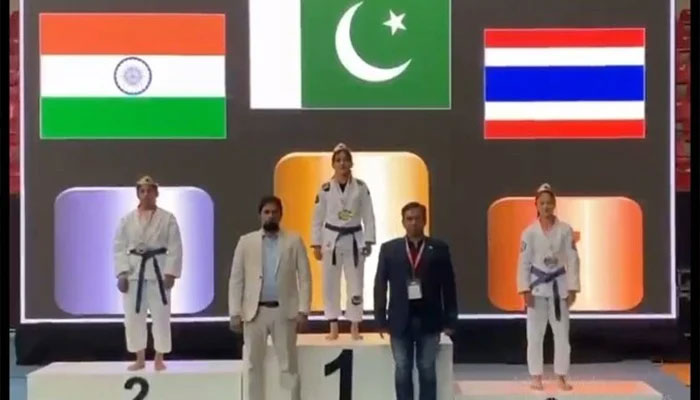 Pakistani athlete Bano Kousar stands on the top podium after clinching gold in an Asian Ju-Jitsu Championship alongside Indian and Thailand atheletes on May 25, 2025. — Reporter/Faizan Lakhani