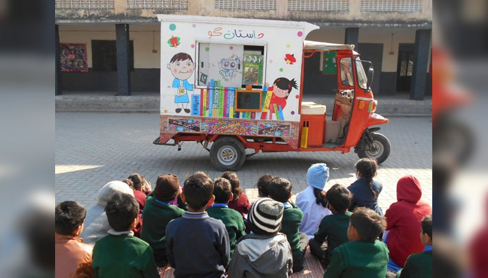 Students attend a rickshaw-turned-librarys session. — aliflaila.org.pk/File