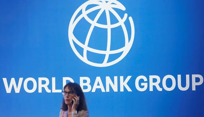 A participant stands near a logo of World Bank at the International Monetary Fund - World Bank Annual Meeting 2018 in Nusa Dua, Bali, Indonesia, October 12, 2018. —Reuters