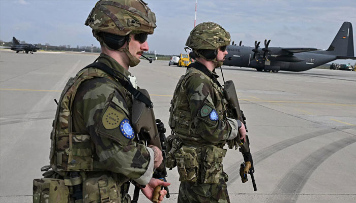 Irish soldiers are pictured next to a German C-130 type military plane at an air base in Hungary on April 10, 2025. — AFP