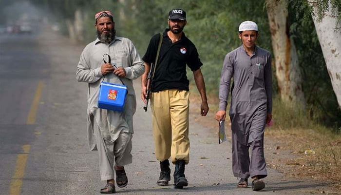 A police personnel guarding polio workers. — Reuters/File