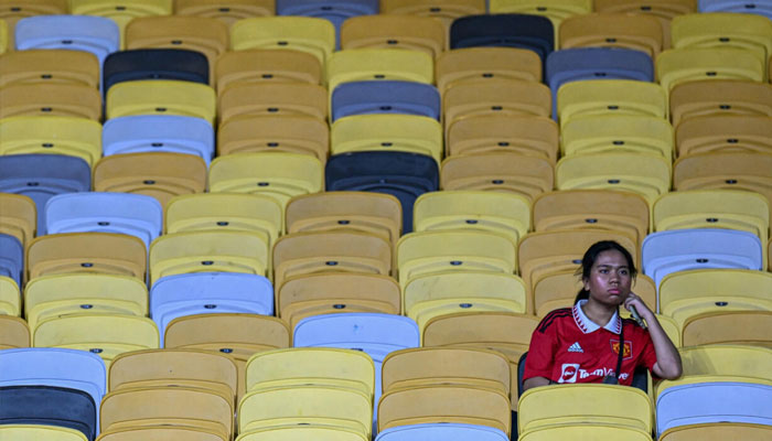 A fan sits in the stands before the friendly between Manchester United and Asian All-Stars. —AFP/File