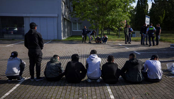 Suspected illegal migrants sit on the ground after they were detained by German police during their patrol along the German-Polish border to prevent illegal migration, in Forst, Germany, September 20, 2023.—Reuters