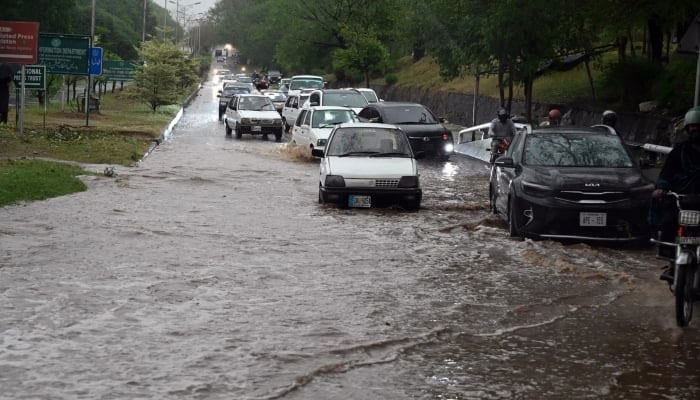 Vehicles making their way through stagnant rainwater accumulated on the road near Zero Point in the Federal Capital after heavy rainfall, Islamabad, May 24, 2025. — APP