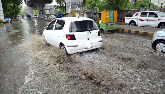 A vehicle passes through stagnant rainwater, causing inconvenience for commuters on Saddar Road, Peshawar, Khyber Pakhtunkhwa, May 27, 2025. — APP