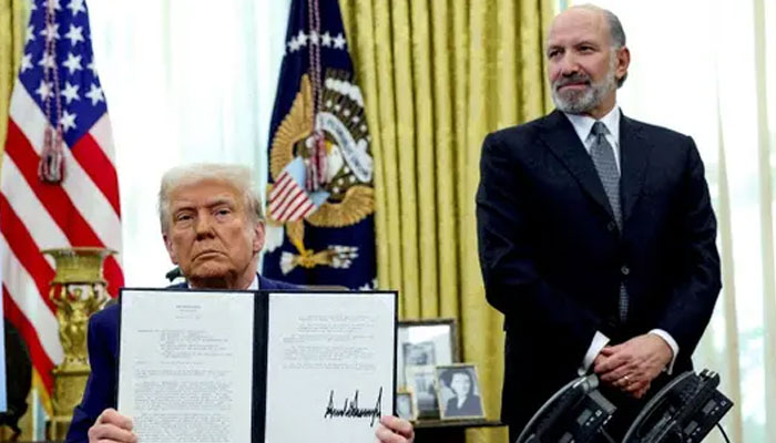 US President Donald Trump holds an executive order about tariffs increase, flanked by US Commerce Secretary Howard Lutnick, in the Oval Office of the White House in Washington, DC, US, February 13, 2025. — Reuters