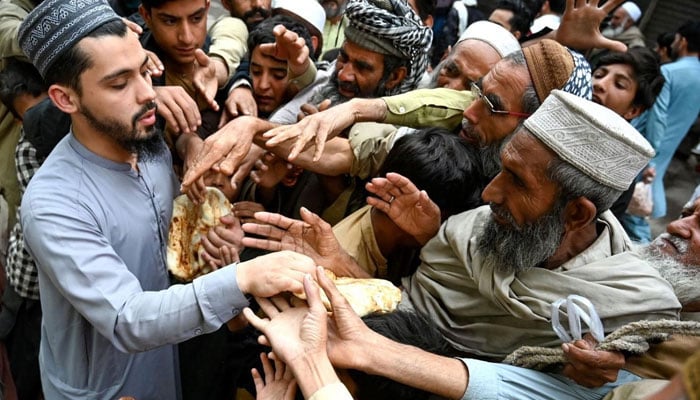 A person distributes meals among people.— AFP/File